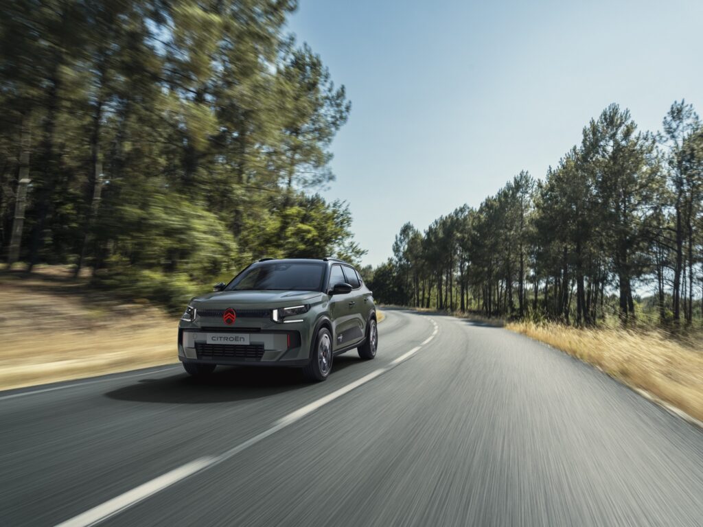 Citroën C3 Outdoor in Sequoia-Grün auf einer Landstraße zwischen Kiefern