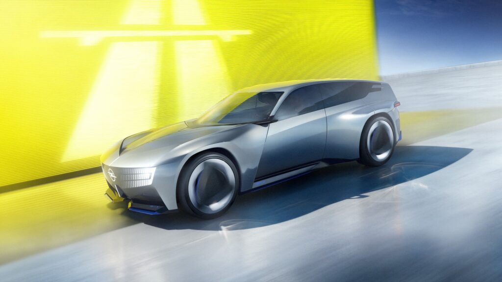 Silberner Opel STX Concept in der Seitenansicht vor gelber Wand