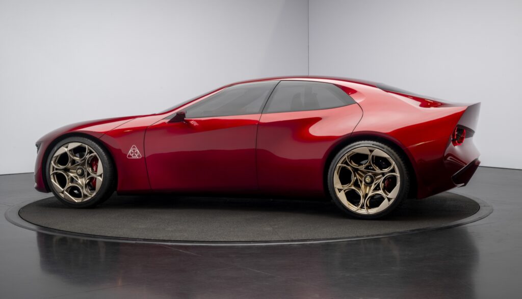 Seitenansicht des roten Alfa Romeo Cuorerosso mit bronzefarbenen Leichtmetallrädern auf einer Drehscheibe