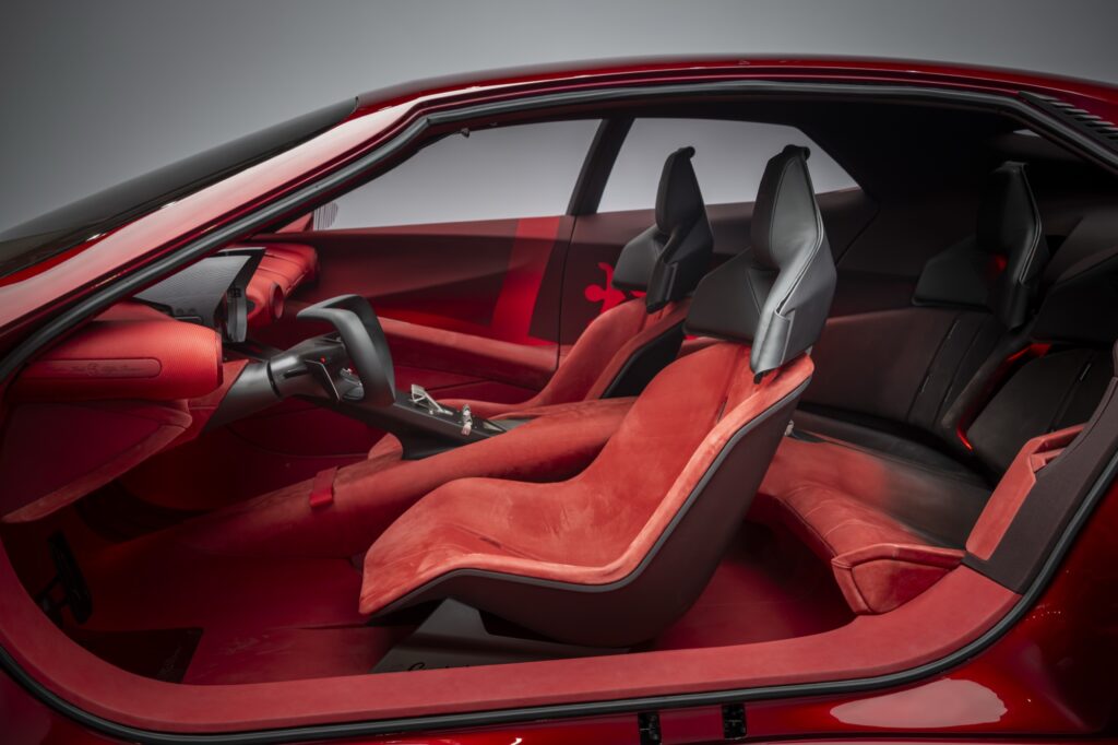 Blick durch die geöffnete Tür in den Innenraum des Alfa Romeo Cuorerosso mit roten Einzelsitzen vorn und hinten