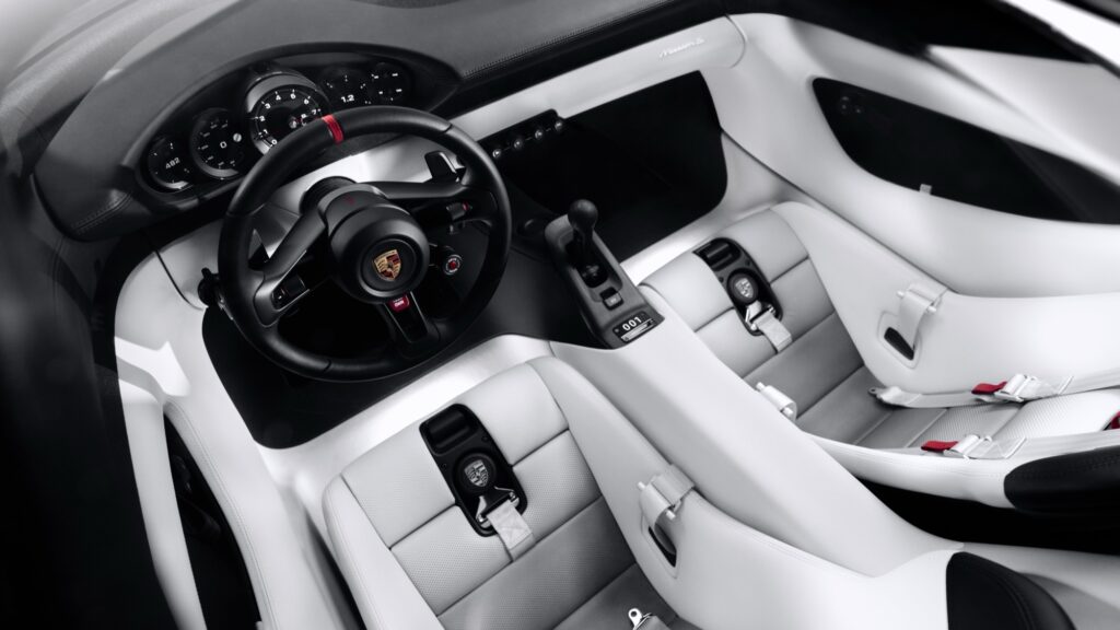 Fahrerplatz des Porsche Mission S mit Lenkrad und Rundinstrumenten in weißem Interieur