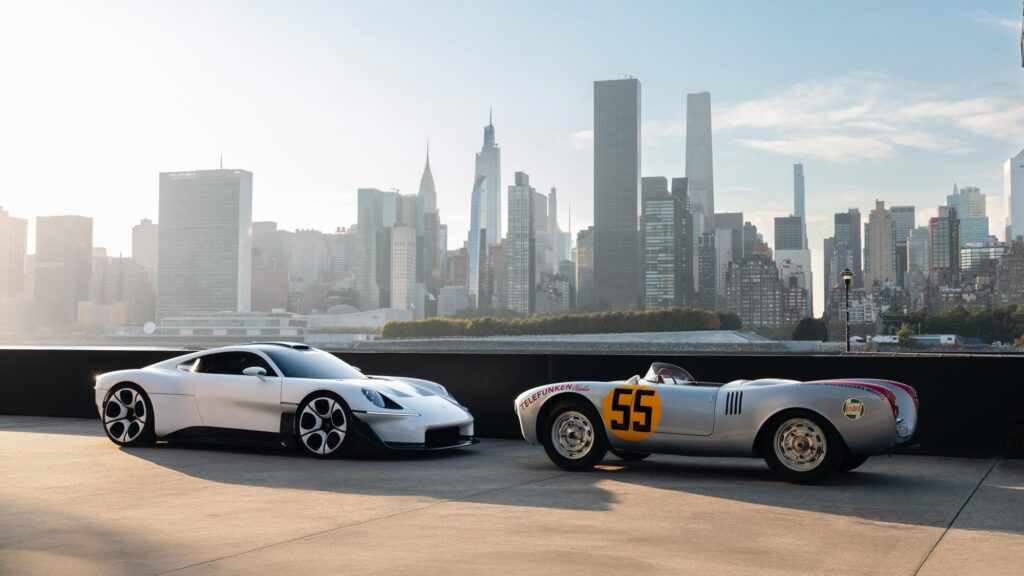 Der weiße Porsche Mission S neben einem historischen Porsche 550 Spyder vor der Skyline von Manhattan