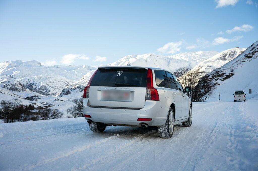 Silberner Volvo-Kombi mit Winterreifen auf einer verschneiten Bergstraße bei Andermatt